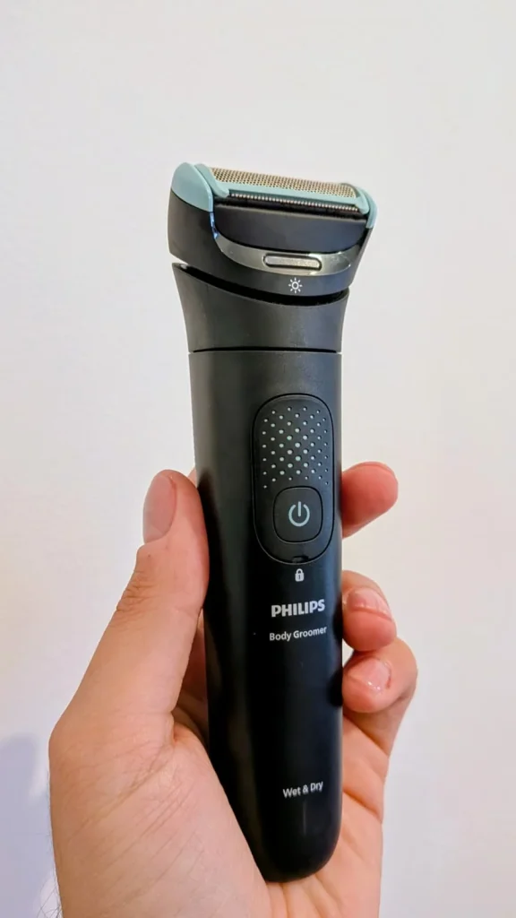 Aparador corporal Philips Body Groomer preto segurado por uma mão.